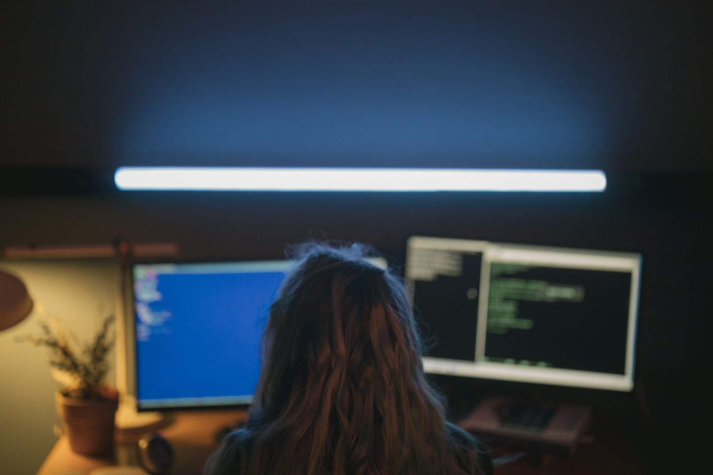 Software engineer working at a dual-monitor development setup
